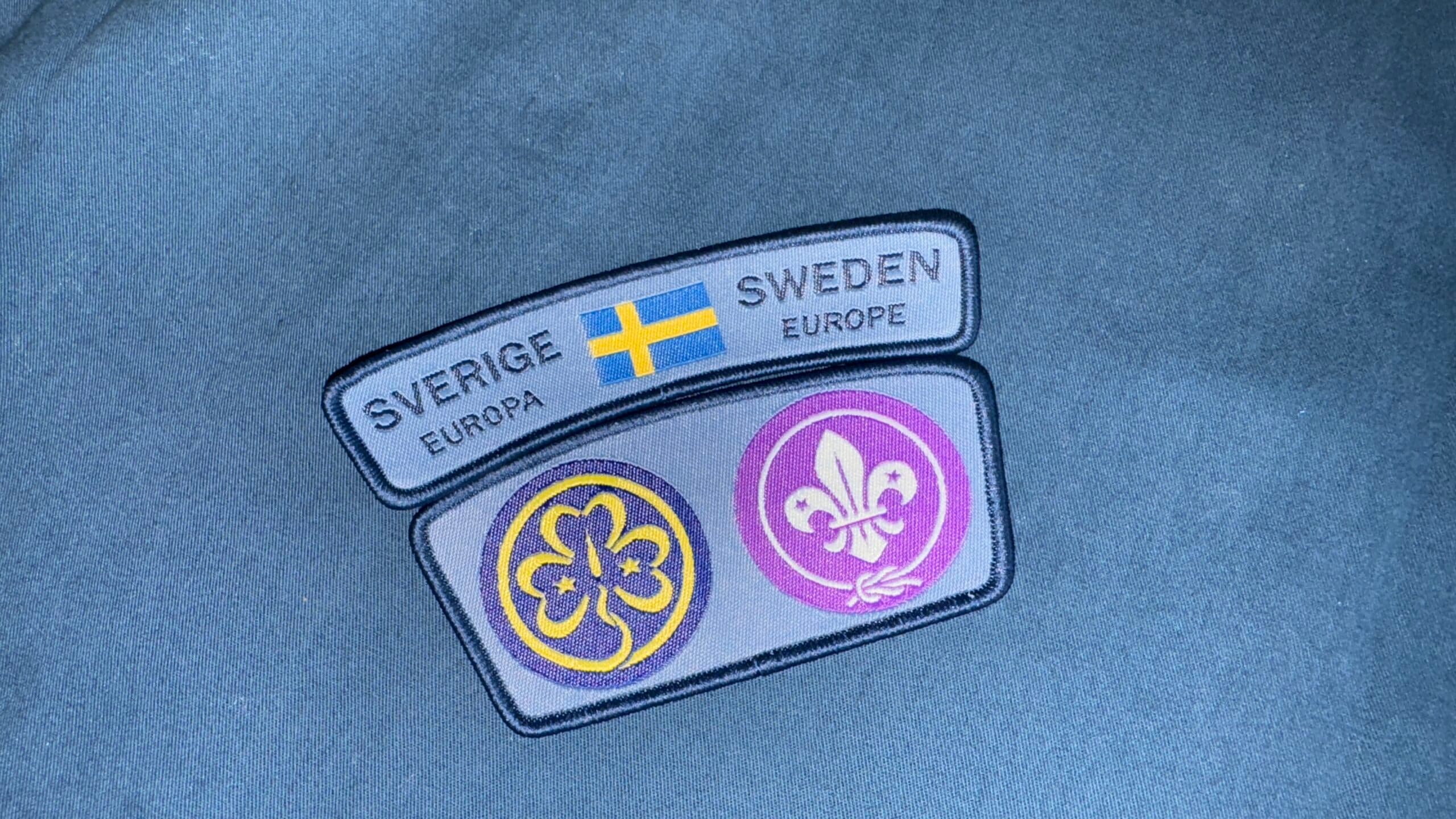 två scoutmärken på en blå bakgrund.