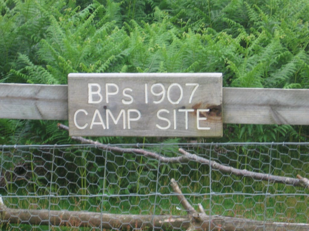 En träskylt där det står "BPs 1907 CAMP SITE"