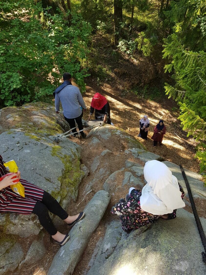 Kvinnor med hijab klättrar i berg på Vässarö under en dagsutflykt med projektet Äg din natur.