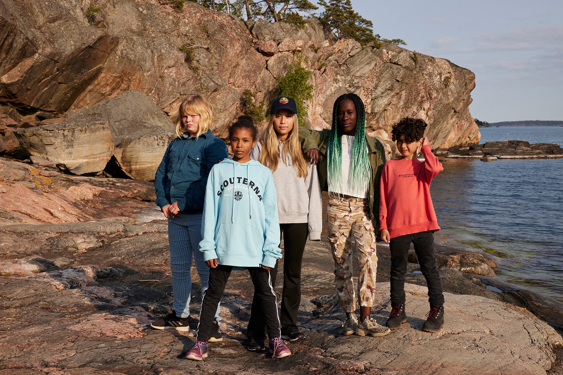 Scouter i grupp på klippa, som blickar in i kameran